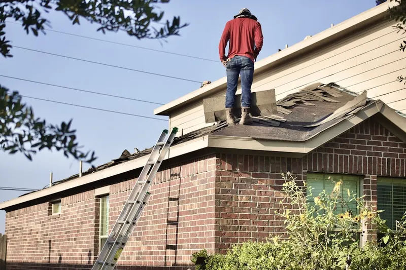 Professional roofer working on a residential roof in Broadstone Village